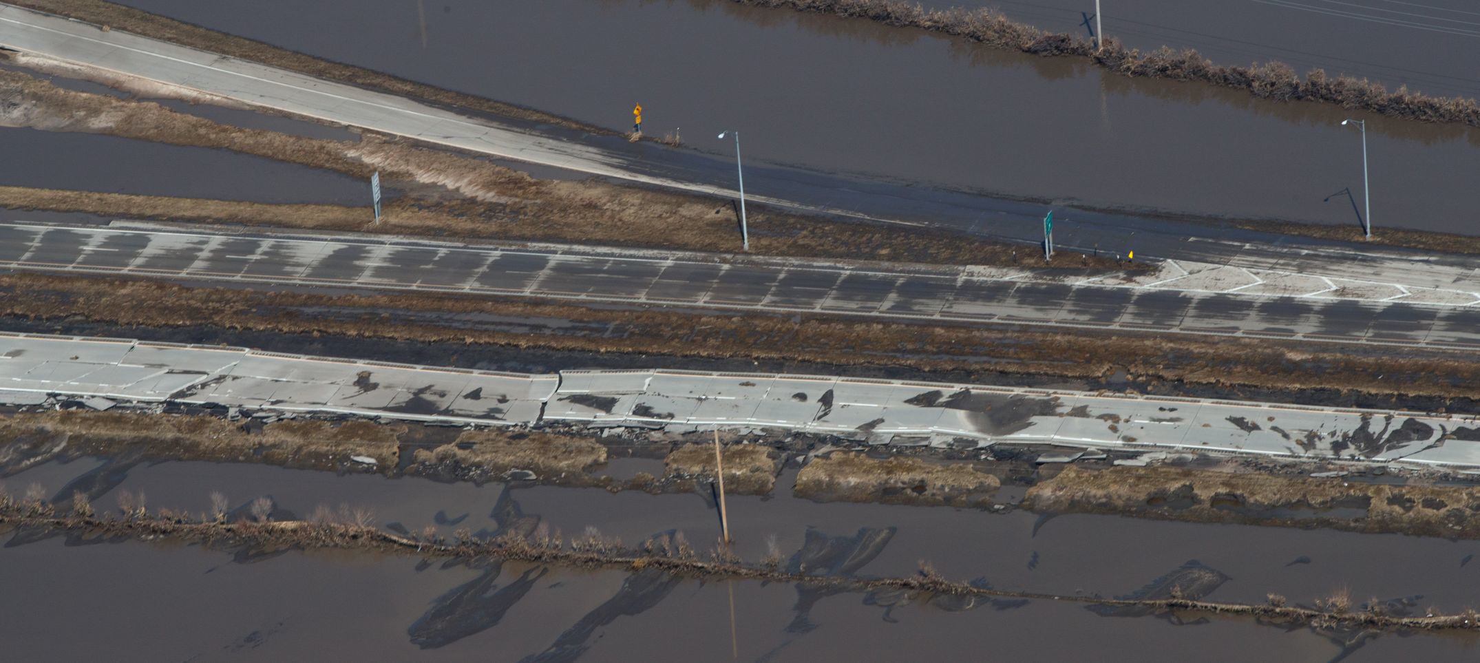 The eastbound lanes of West Dodge Road just west of 228th Street show the damage done after floodwaters went down Monday.